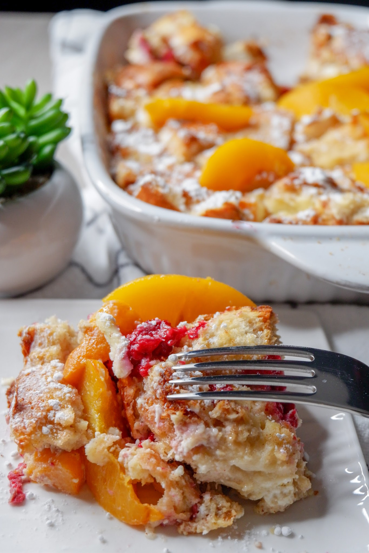 Whip up this raspberry peach baked french toast recipe the night before, so all you have to do is toss it in the oven to bake in the morning. An overnight french toast bake that is filled with fruit and tender french bread. #easy #best #frenchtoast #casserole #overnight #fruit #oven #brunch #holiday #breakfast