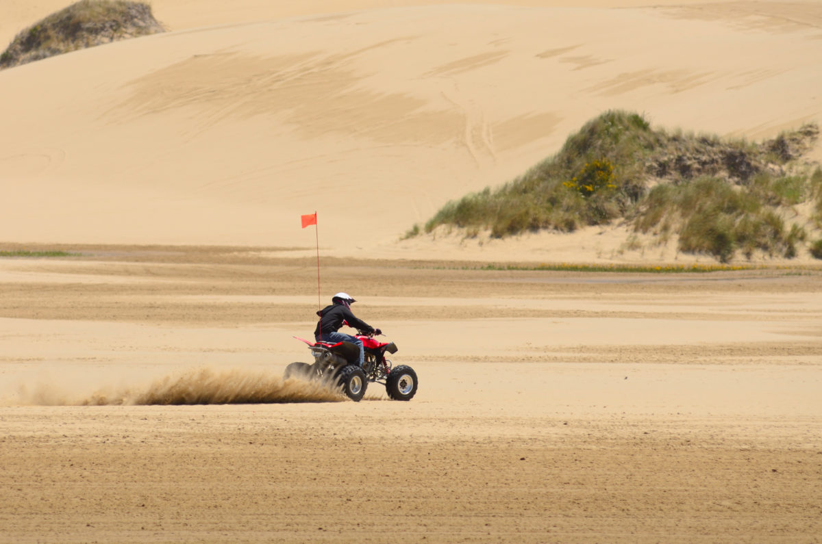 A person riding an atv in the sand dunes
