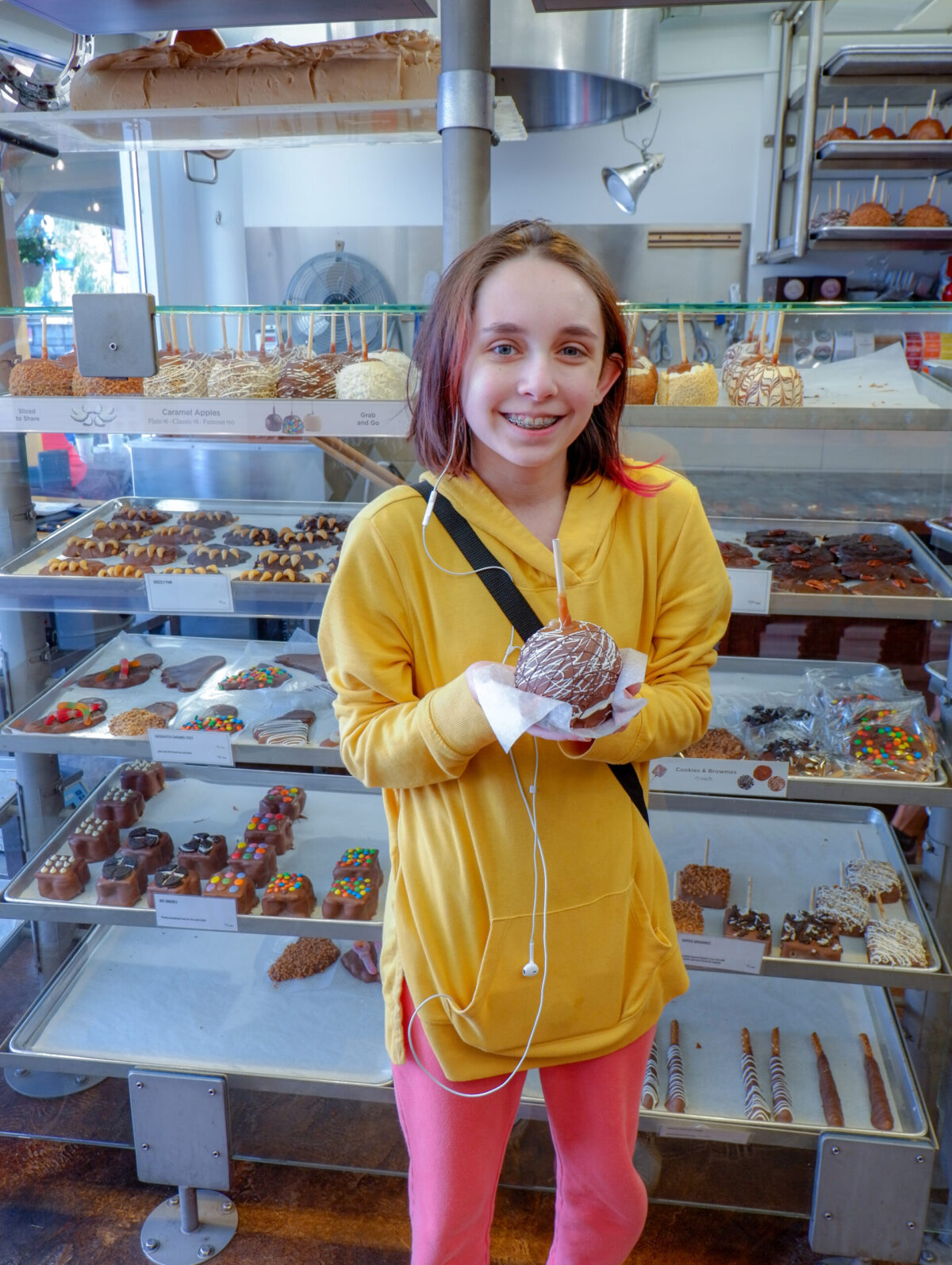 daughter holding candied chocolate apple at Rocky Mountain chocolate