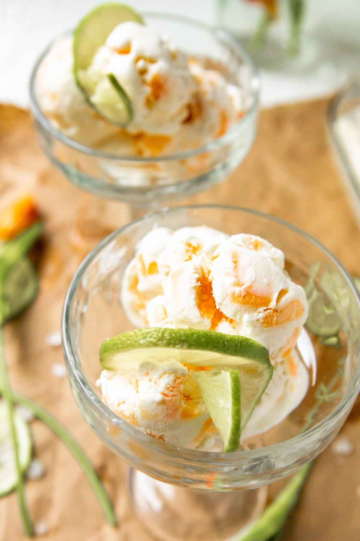mango ice cream in glass bowls with lime slices