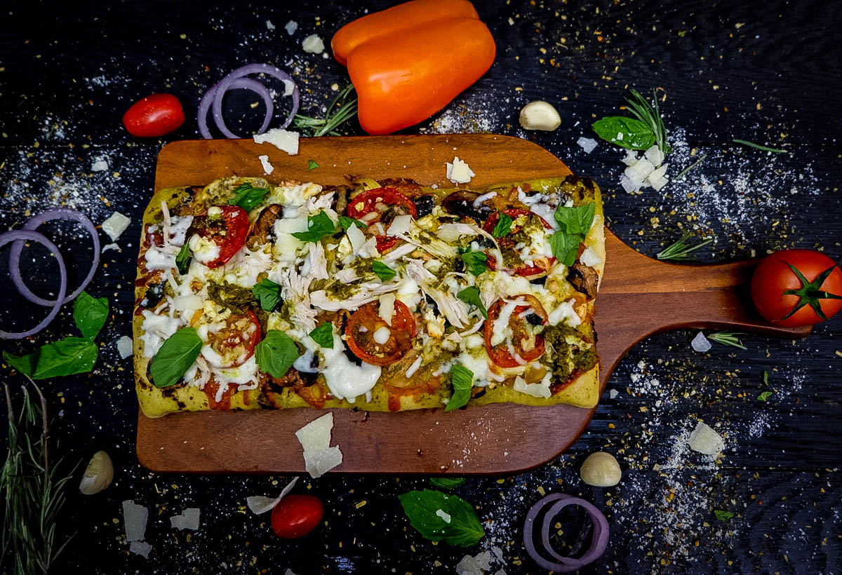 Pesto chicken pizza on a cutting board
