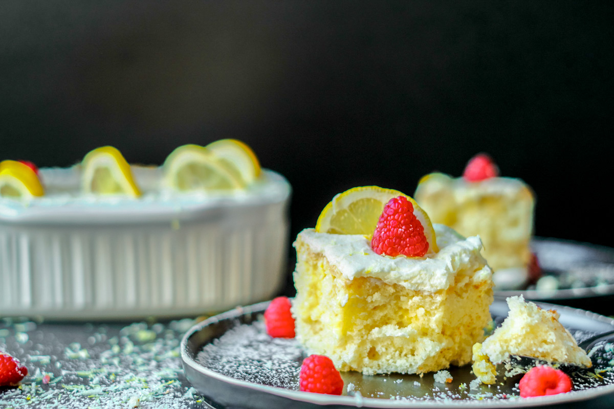 lemon poke cake slice with raspberry on top