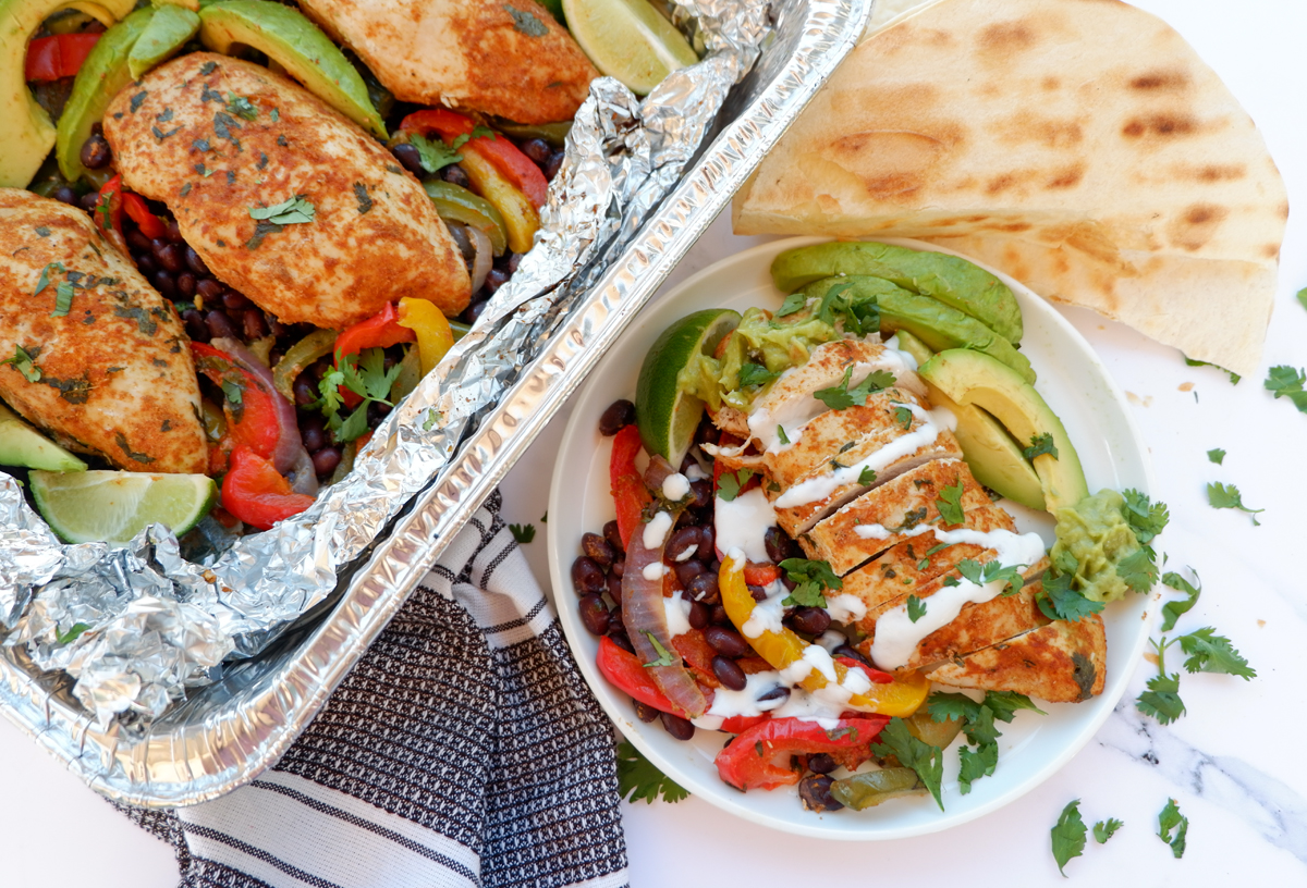 chicken fajita foil packets. Chicken foil packet and plated chicken breast on black beans, bell peppers and avocado on the side