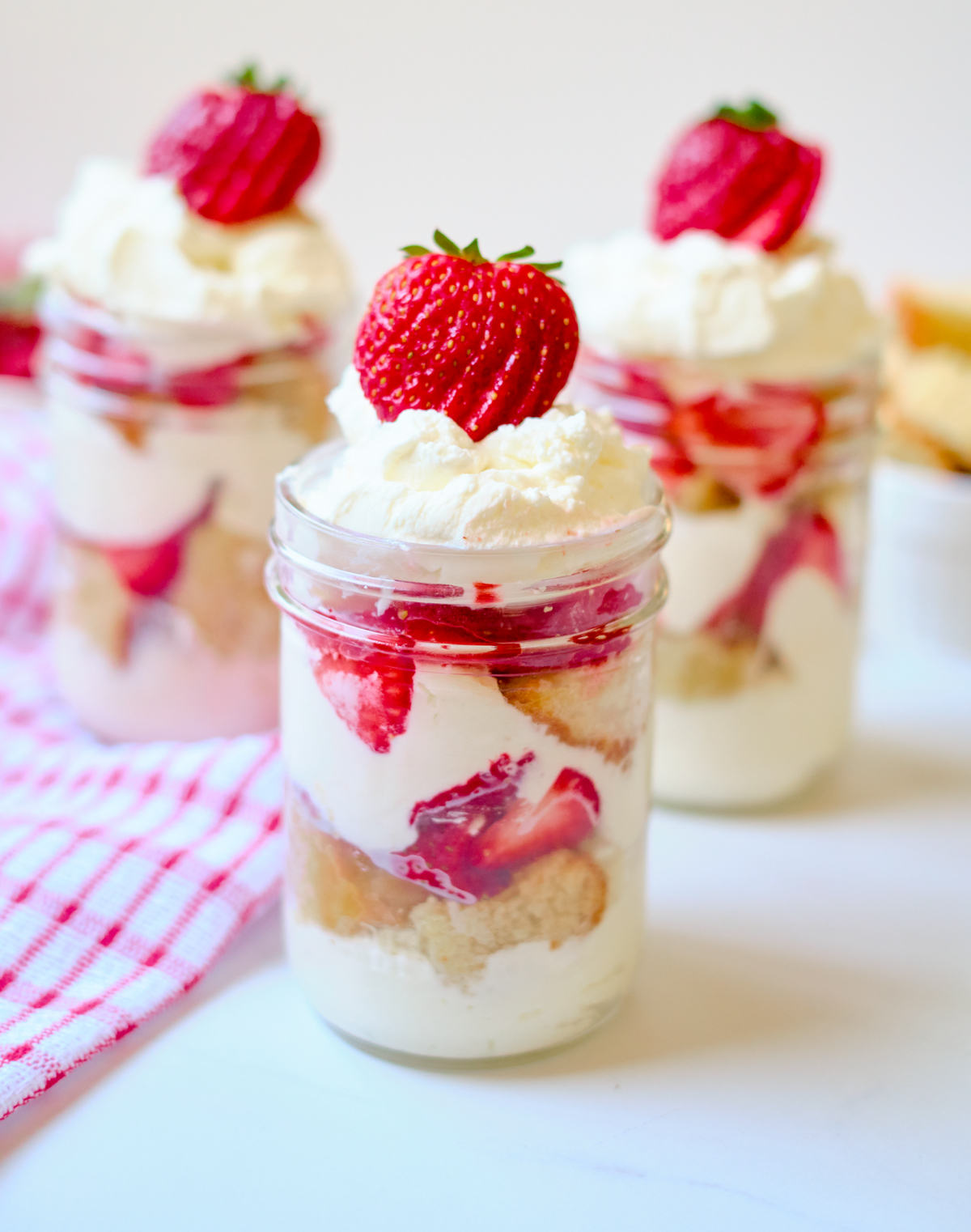 Can I Make These in Advance? You can make the cake one to two days ahead of time (if it gets a little dry, don’t worry! The whipped cream and fresh strawberries will moisten the cake again). However, I’d wait to assemble the strawberry trifles until the day of, otherwise they’ll become soggy. Tips for the Best Strawberry Shortcake Trifles If you don’t have a cookie or biscuit cutter, simply cut out the cake layers with the top of the jar. Frozen strawberries can’t be used in this recipe. They’re too soggy and the flavor isn’t as good! For a less sweet treat, scale back on the amount of sugar in the whipped cream.
