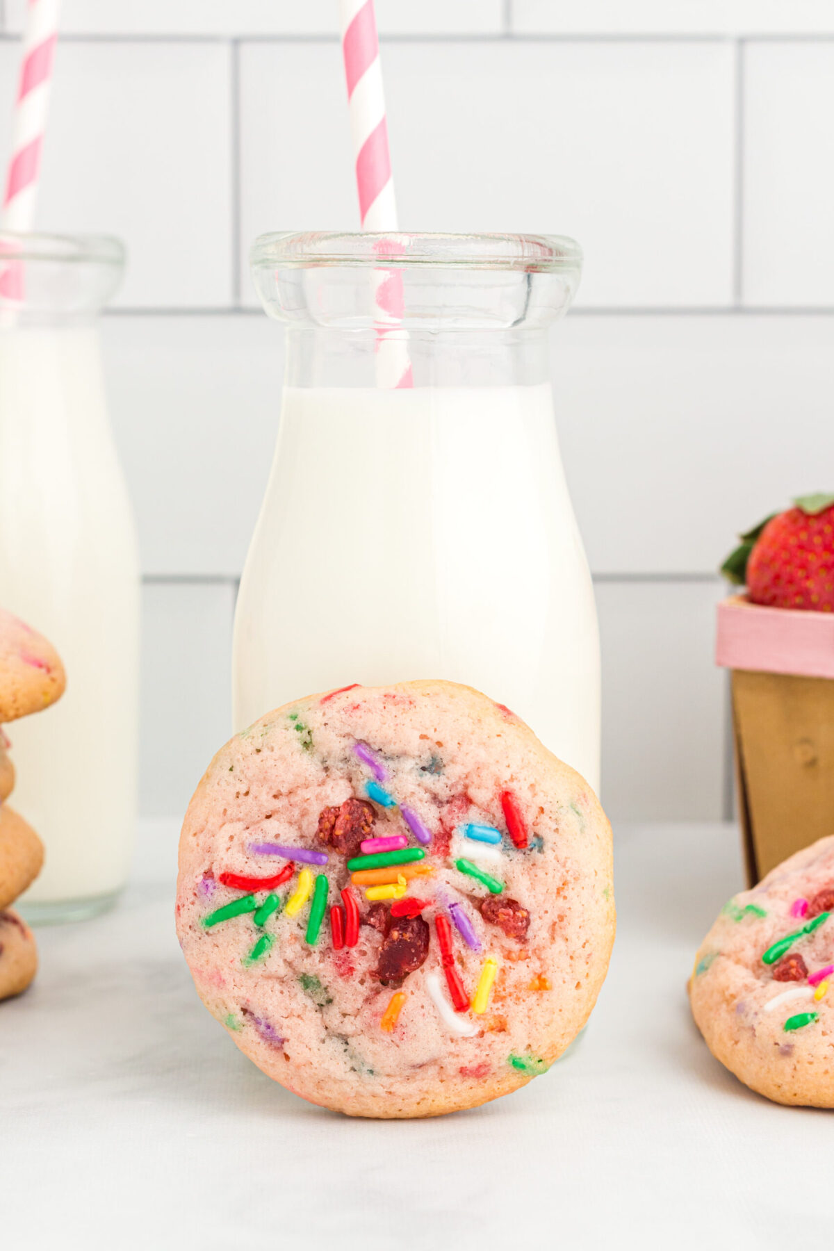 1 cookie centered in front of a glass milk jug with a red and white striped straw unique cookie recipes